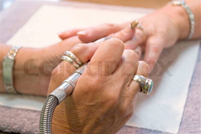 A professional nail technician working on a clients nails, stock photo