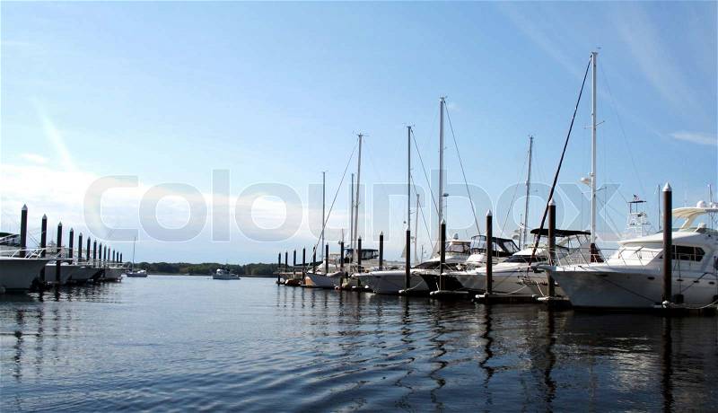 Luxury yachts docked at marina, stock photo
