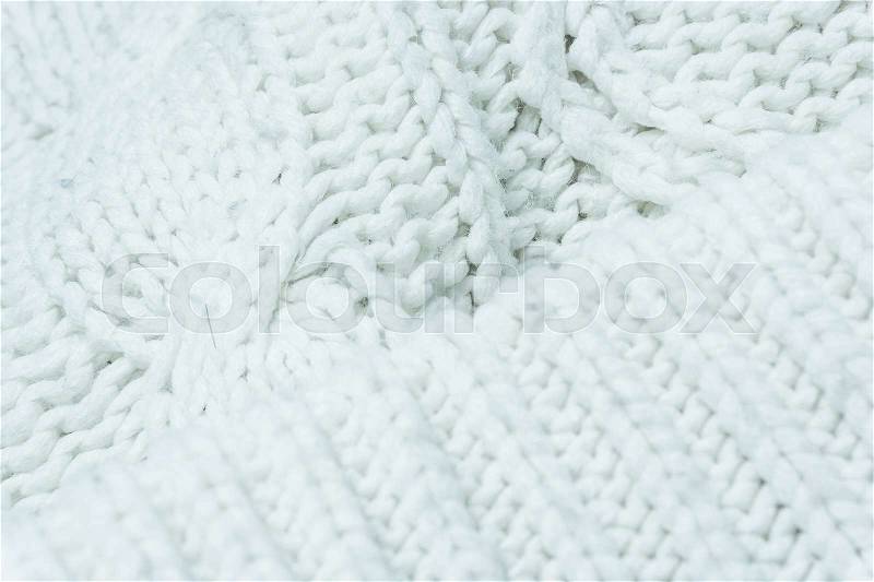 Knitted fabric texture. Knitted jersey background with a relief pattern. Braids in knitting, stock photo
