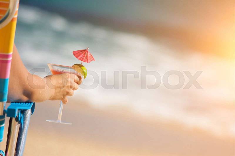 Woman Relaxing on Beach with Tropical Drink, stock photo