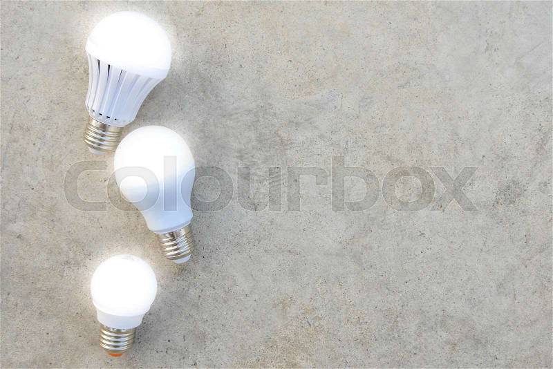 LED Bulbs with lighting on the concrete floor, stock photo