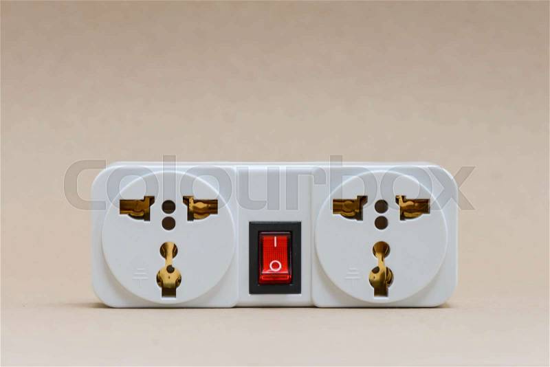 Electric travel outlet with red button switch on the brown background, stock photo
