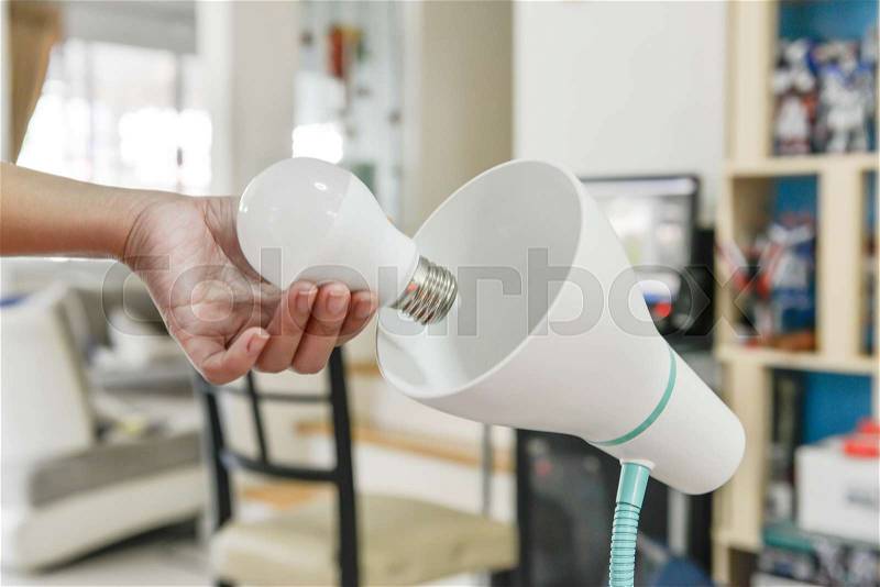 Changing bulb to LED to use with lamp, stock photo