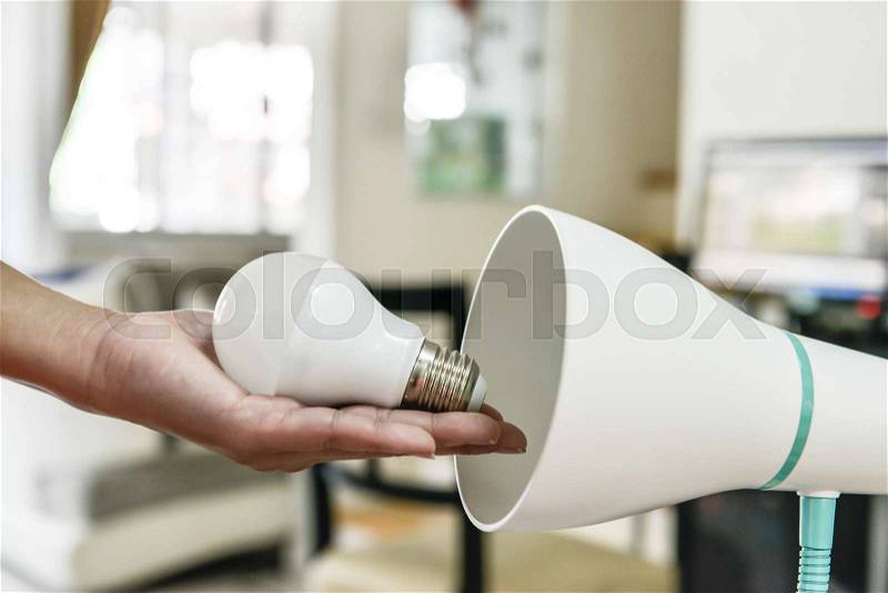 Changing bulb to LED to use with lamp, stock photo