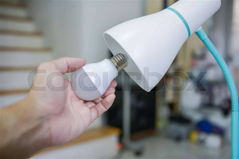 Man hand changing the LED bulb to white lamp - Saving energy concept, stock photo