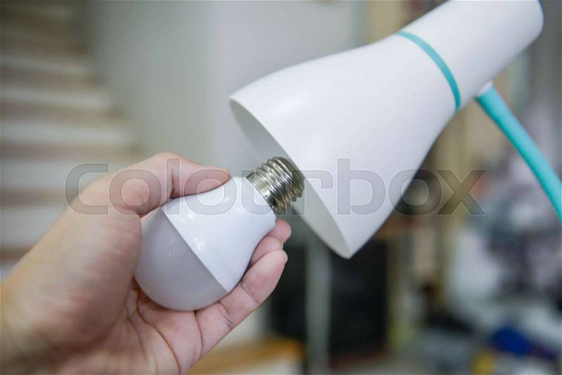 Man hand changing the LED bulb to white lamp - Saving energy concept, stock photo