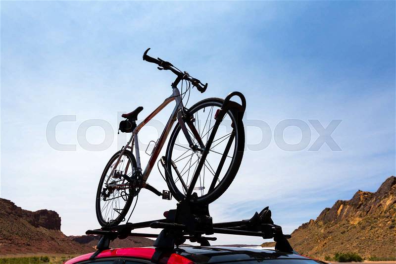 Bike transportation on the roof of a car. Blue sky and mountains on the background, stock photo