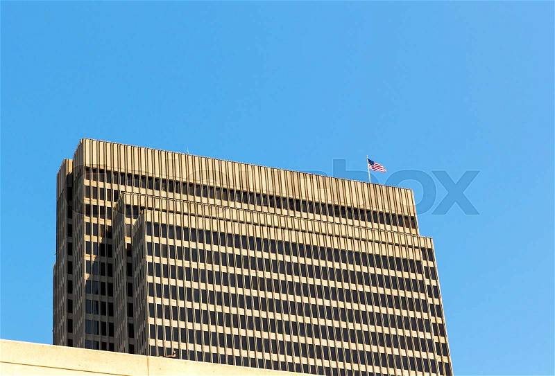 Skyscraper with US flag on roof. Closeup of house top floors and roof, stock photo