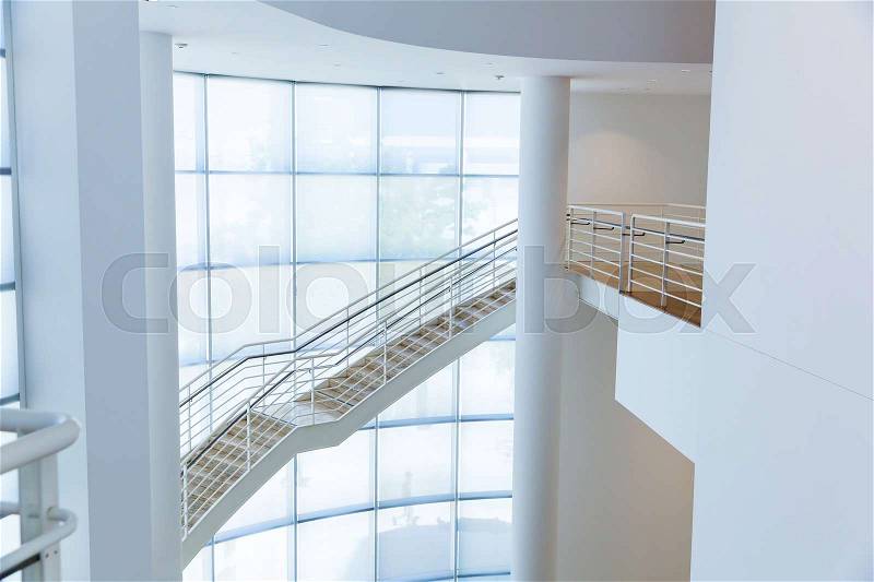Staircase with metal handrails against glass cube wall. High tech architecture, stock photo