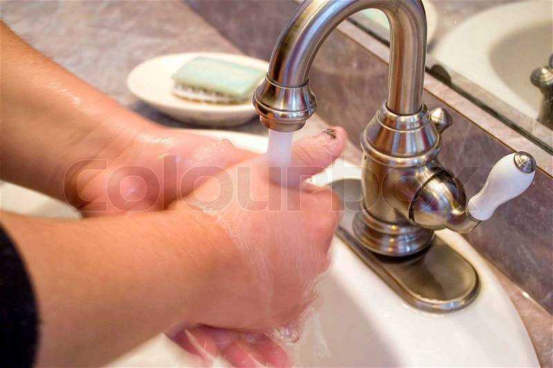 A person washing their hands in the bathroom sinkSlightly soft - best at smaller sizes, stock photo