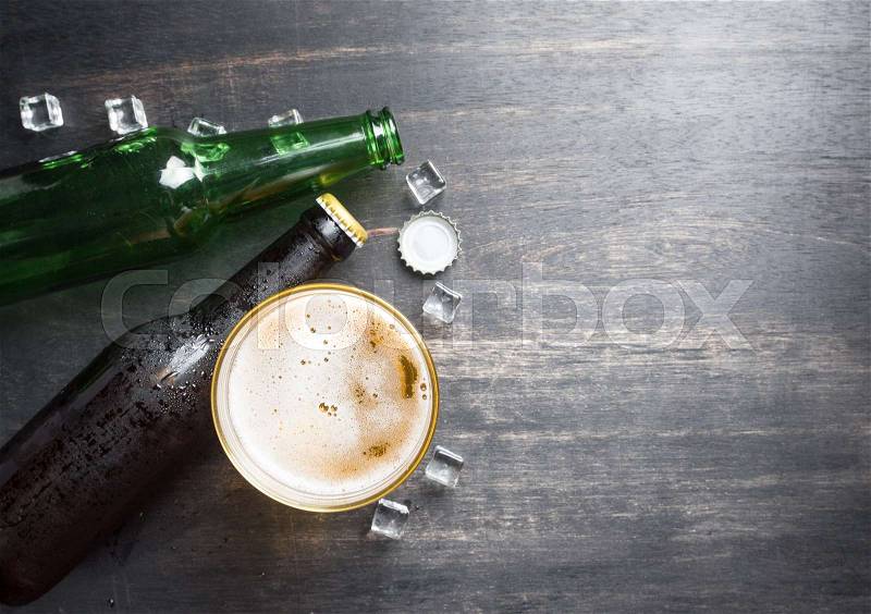 Beer glass with bottle cap and bottle on rustic wood background,space for text,top view, stock photo