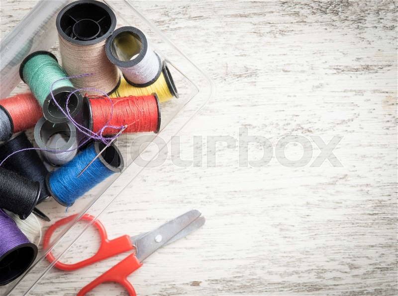Sewing accessories,spools of thread with scissors on wood background,top view, stock photo