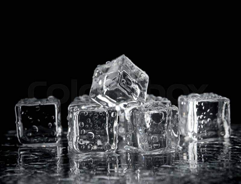 Ice cubes on reflection table on black background, stock photo