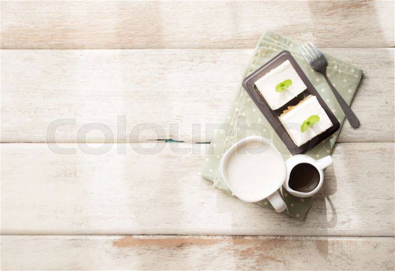 Glass of milk and milk cake delicious on the wood table with shadows from a window frame,top view, stock photo