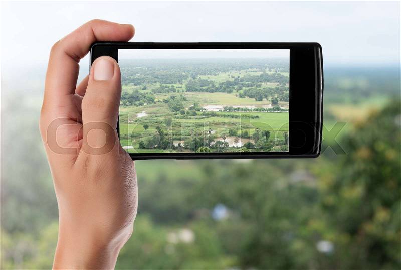 Hand taking picture at the mountain landscape with a smart phone, stock photo
