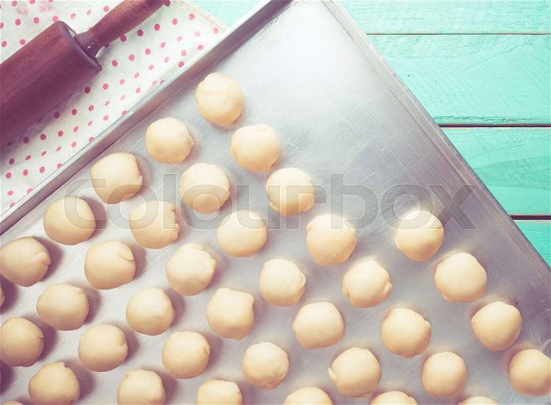 Dough and wooden rolling pin on blue wooden table,vintage color toned image, stock photo