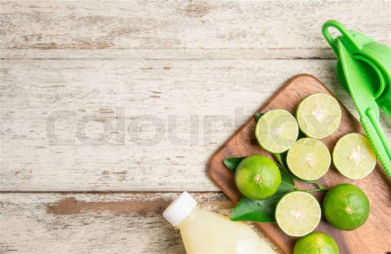 Freshly squeezed lime juice with lime fruits on wood table,top view, stock photo