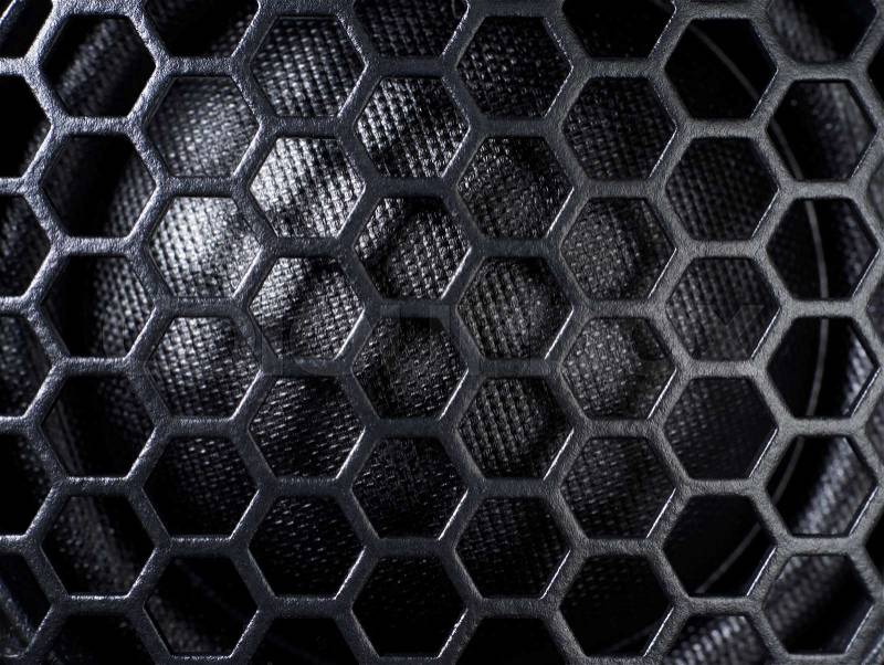Full frame black grid of a speaker detail in dark back, stock photo