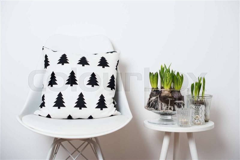 White scandinavian spring interior closeup, minimalist furniture and hyacinths in a jar, stock photo
