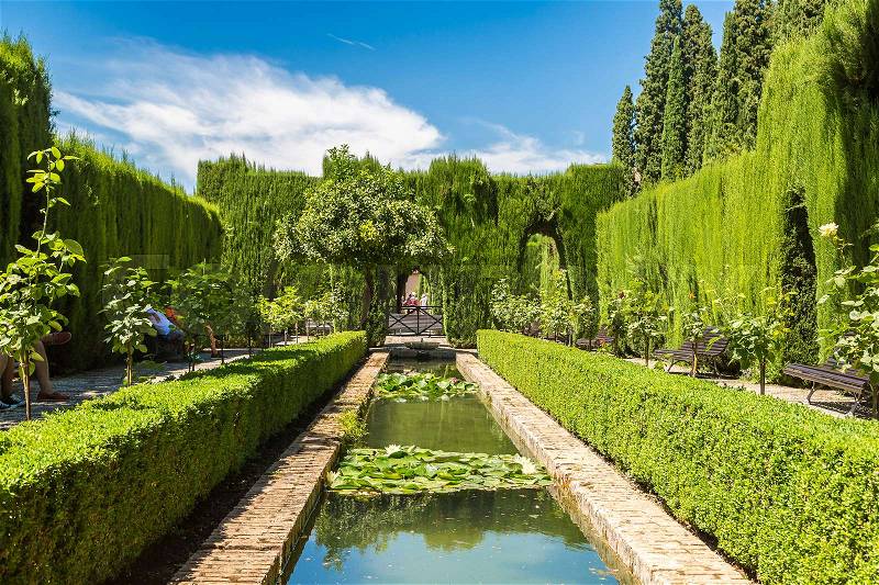 Gardens and fountains in Alhambra palace in Granada in a beautiful summer day, Spain, stock photo