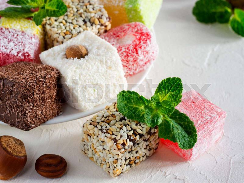 Turkish delight on white rustic background. Turkish deligh set. Assorted traditional turkish delight on oriental background, stock photo