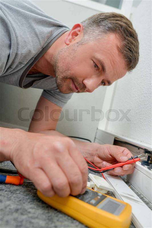 Man repairing an outlet, stock photo