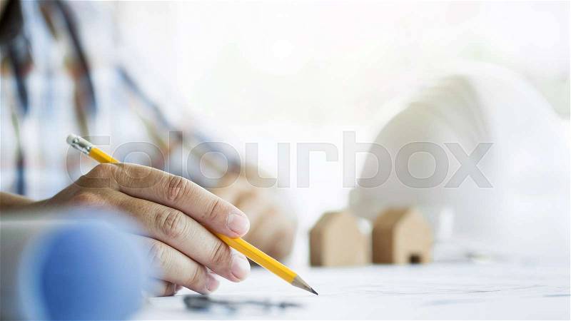 Close-up Of Person\'s Hand Drawing Plan On Blue Print with architect equipment, stock photo