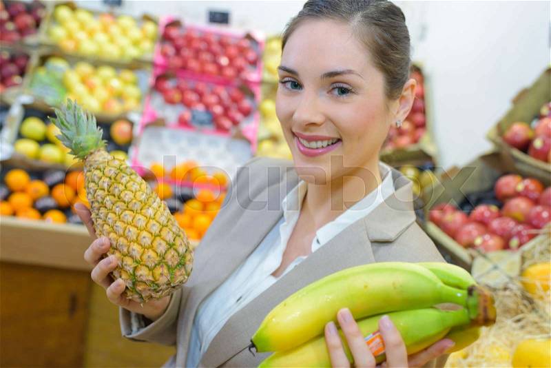 Pretty woman buying fresh fruits and vegetables at food-store, stock photo