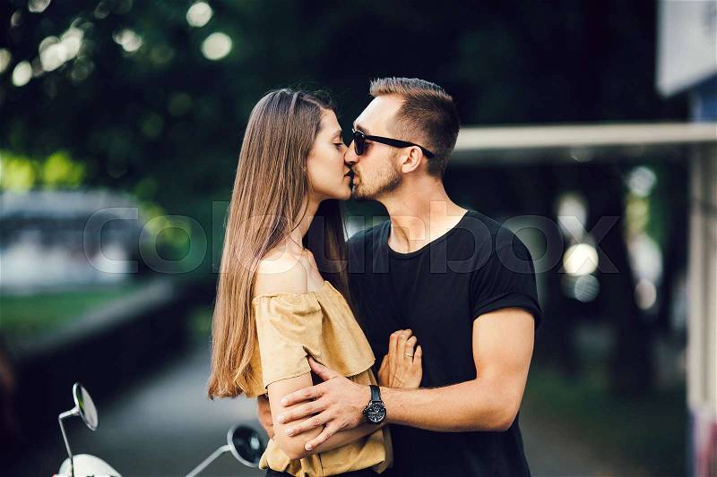 Cute couple kissing on a sunny day in the city, stock photo