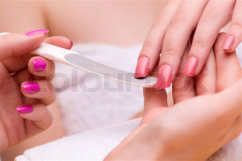 Woman hands during manicure session, stock photo
