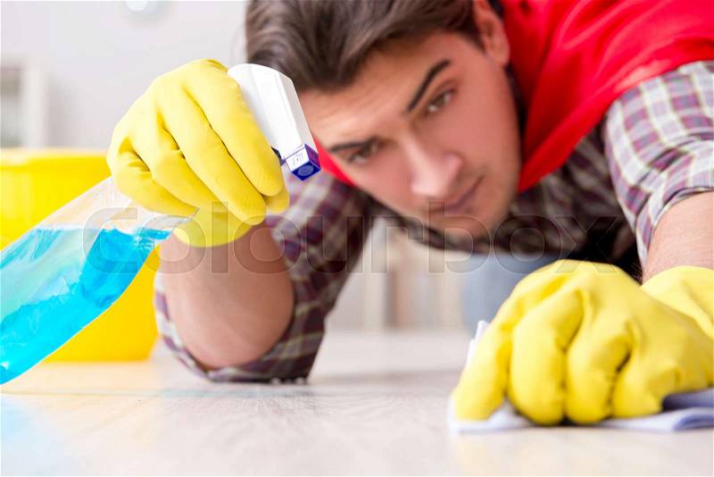 Super hero husband cleaning floor at home, stock photo