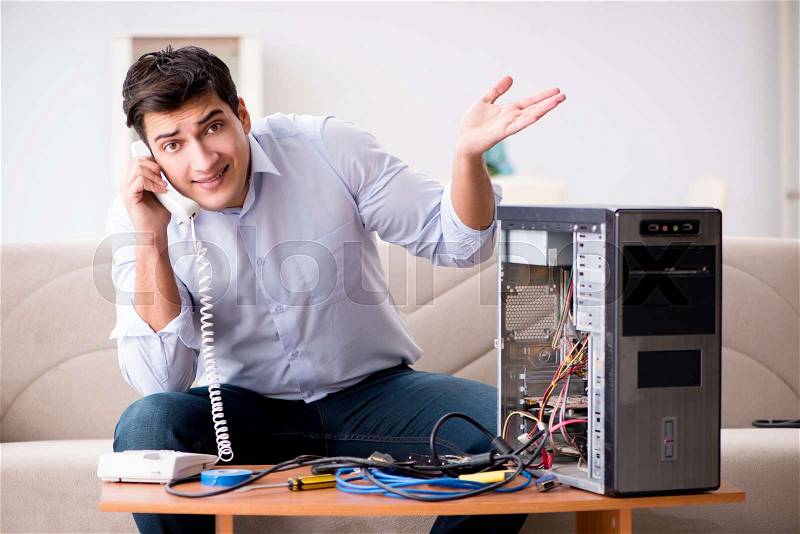 Angry customer trying to repair computer with phone support, stock photo