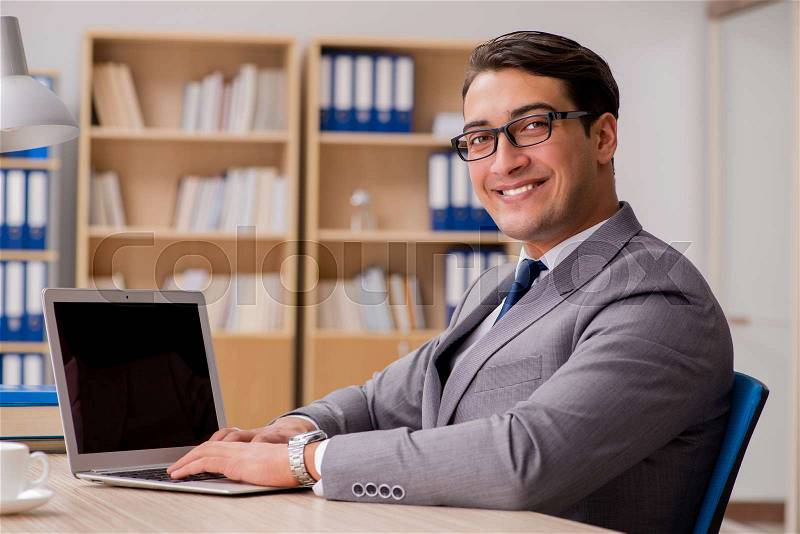 Young handsome businessman working on office, stock photo