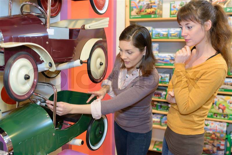 Females reviewing car toys, stock photo