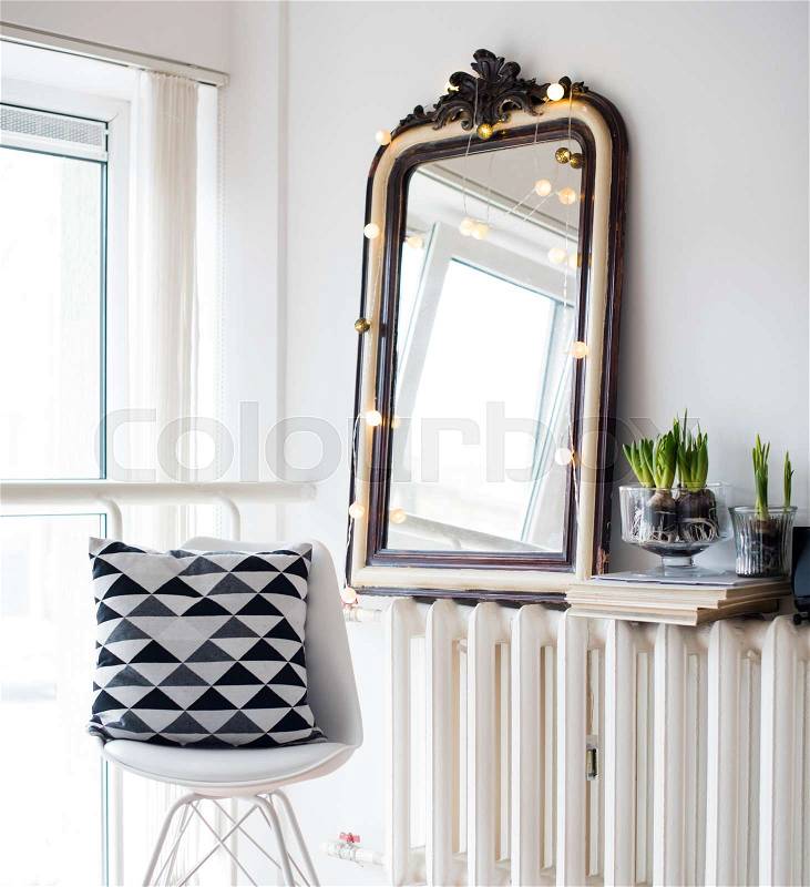 White scandinavian spring interior, hyacinths in a jar, minimalist room decor with chair and vintage mirror, stock photo