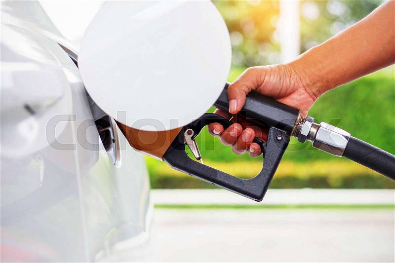 Hand with the fuel nozzle in the car, stock photo