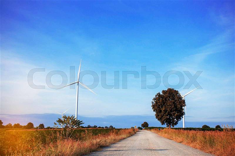 Road in the wind turbines farm with the blue sky, stock photo