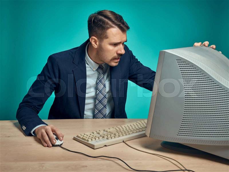 Surprised Young Man Working On computer At Desk, stock photo