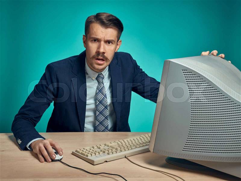 Surprised Young Man Working On computer At Desk, stock photo