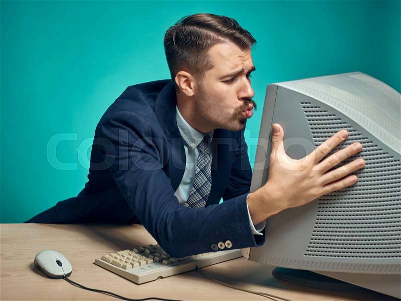 Portrait of cheerful young businessman sitting with computer, stock photo