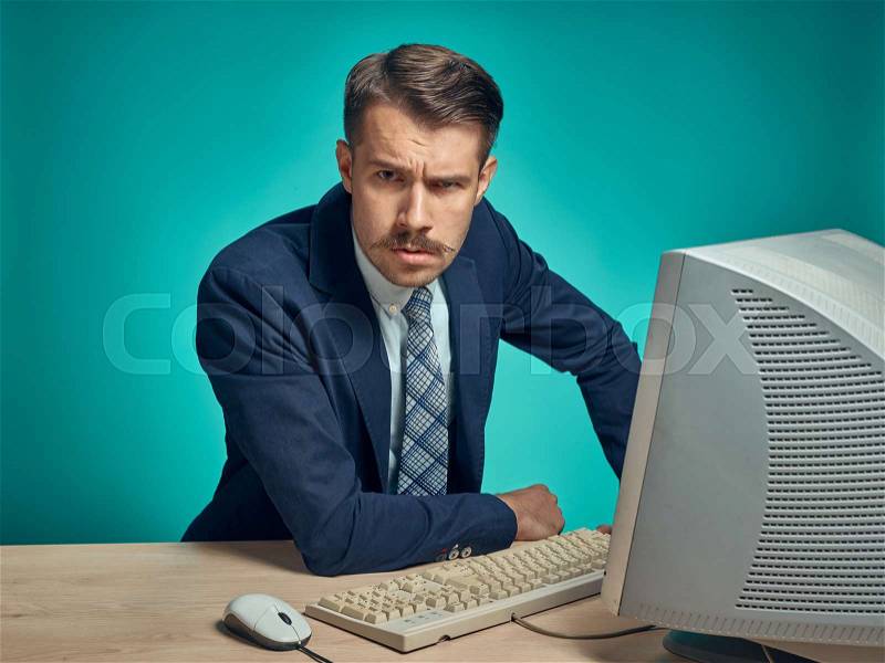 Sad Young Man Working On computer At Desk, stock photo