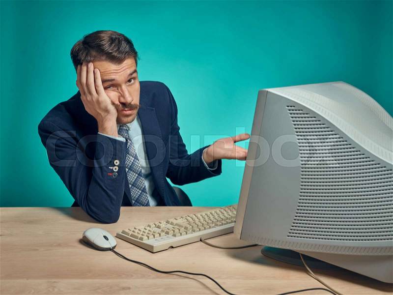 Sad Young Man Working On computer At Desk, stock photo