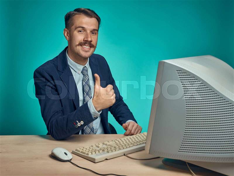 Portrait of cheerful young businessman sitting with computer, stock photo