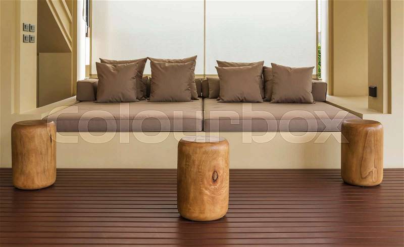 Outdoor patio seating area with big brown sofa and pillows, stock photo