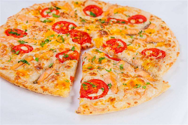 Top view sliced Pizza with Mozzarella, Salmon Slices and Vegetables on the white background isolated. Selective focus, stock photo