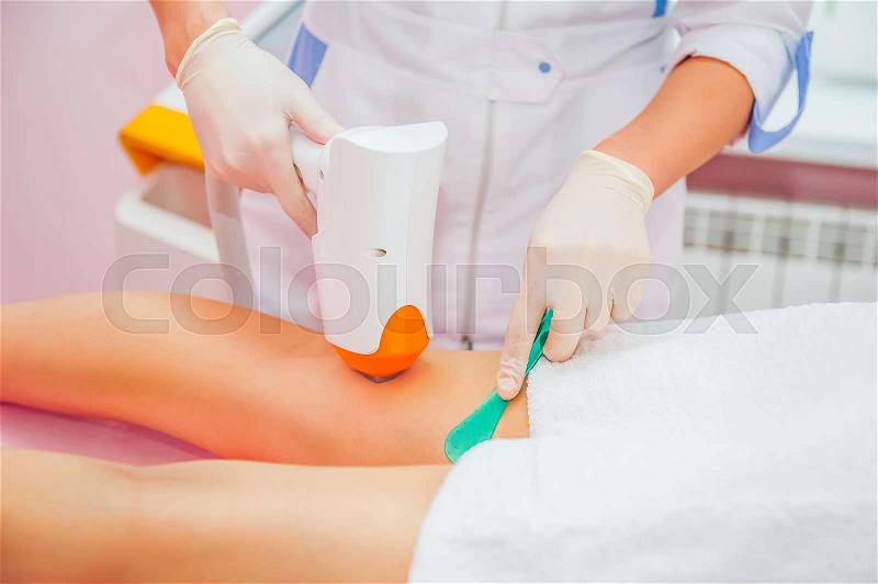 Close up Laser hair removal in the beauty salon. Woman having legs epilation. Selective focus, stock photo
