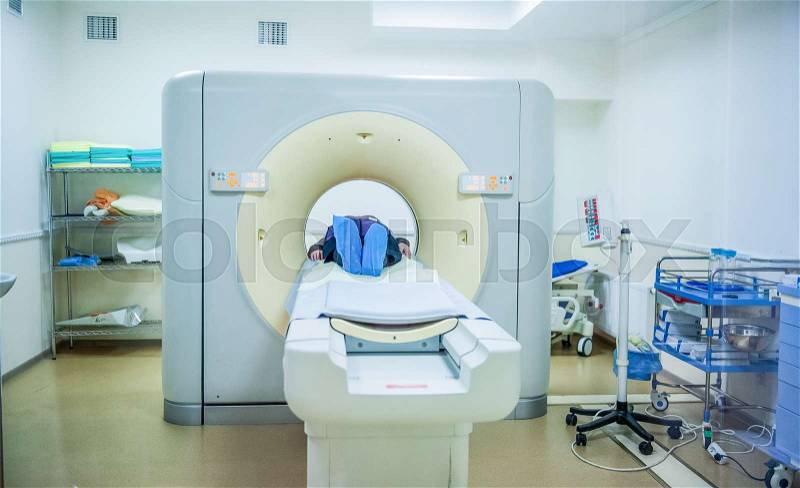 Computed tomography or computed axial tomography scan machine with patient in hospital room, stock photo