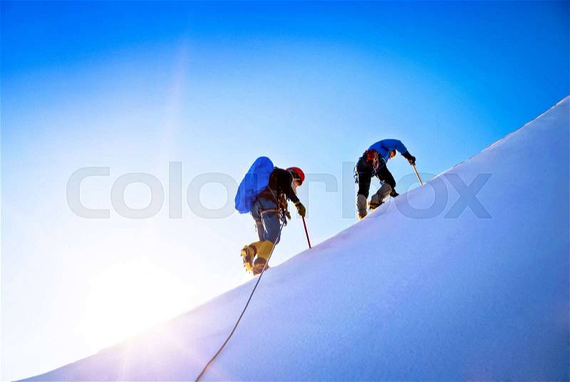Team of two alpinists climbing a mountain. Extreme sport concept, stock photo