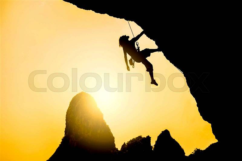 Silhouette of man climbing at sunset. Extreme sport concept, stock photo