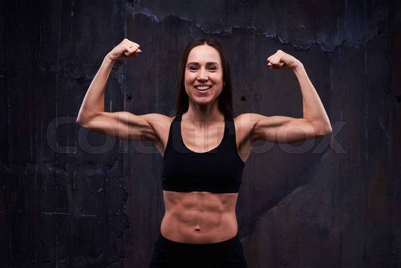 Close-up of fitness model showing trained biceps. Slim model showing the great relief of trained muscled arms and body. Biceps concept. Fitness sport training lifestyle, stock photo